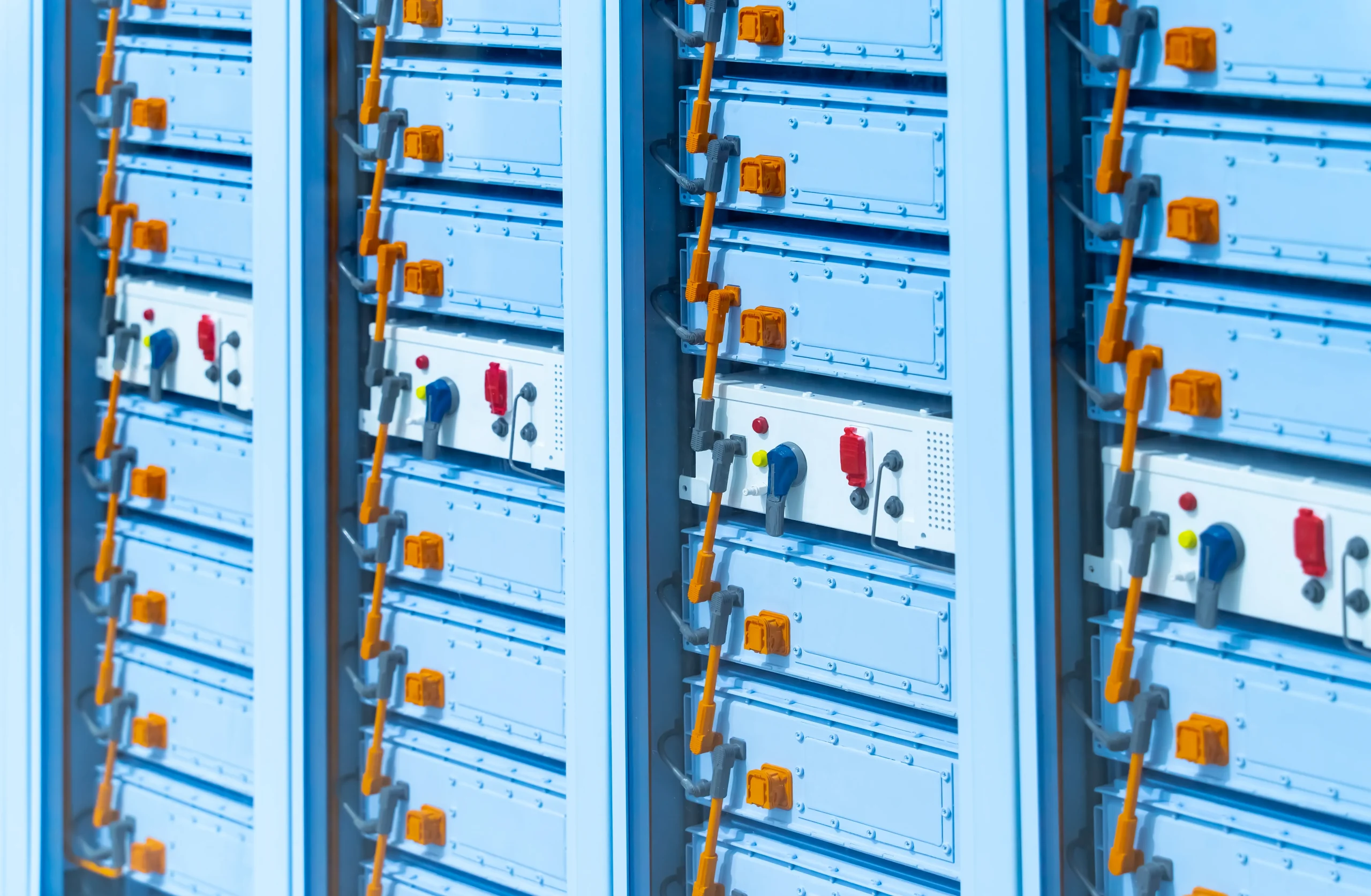 Industrial power distribution system with multiple blue control cabinets featuring orange connection ports, red/blue toggle switches, and status indicators. Modular cabinet design with integrated cable management demonstrating scalable power control solutions.